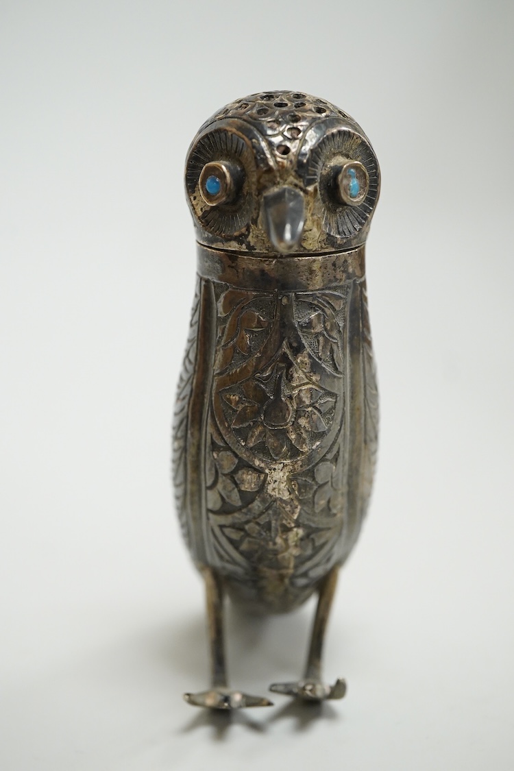A novelty white metal pepperette, modelled as a free standing bird, with blue glass eyes, indistinct mark to one leg, height 87mm.
